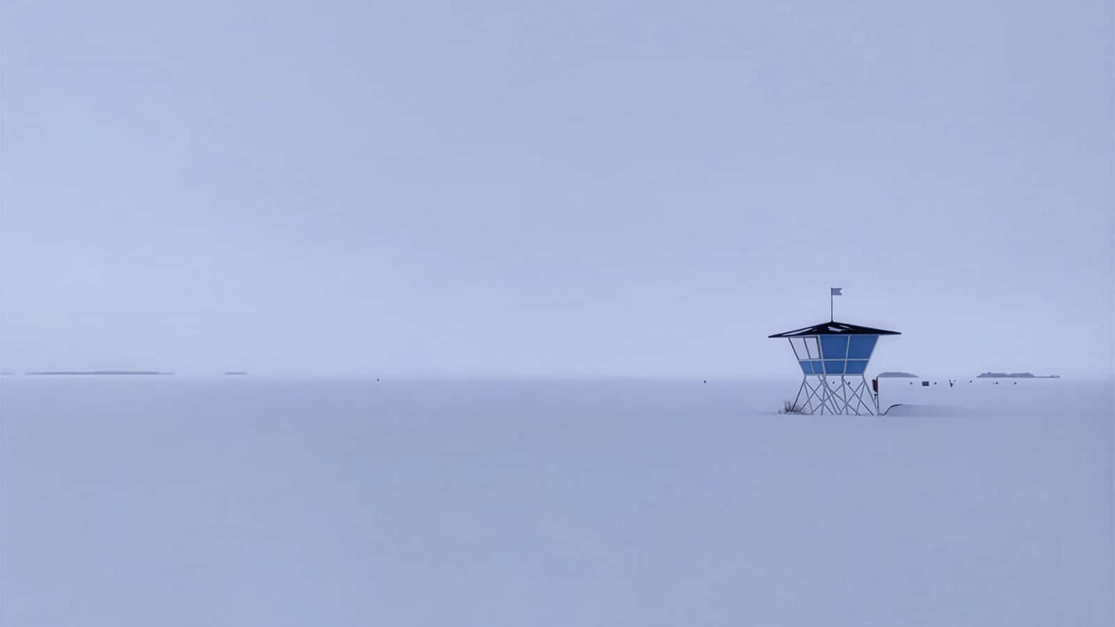 A lifeguard tower on a frozen sea, in fog